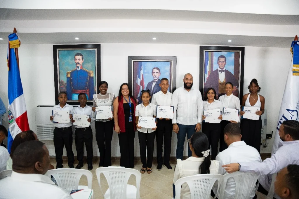 El vicerrector del ITLA, Gary Ruíz, posa junto a un grupo de estudiantes graduados del programa de Educación Continua en la extensión de Monte Plata, tras culminar cursos técnicos en áreas como programación, redes, soporte técnico e inglés